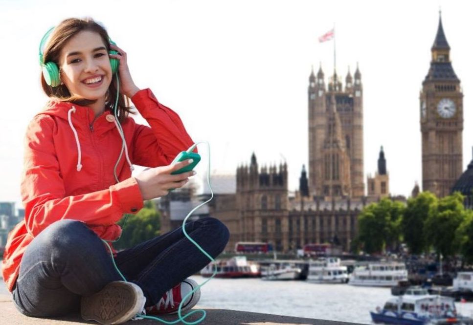 A high school student listening to music and looking at Big Ben in London