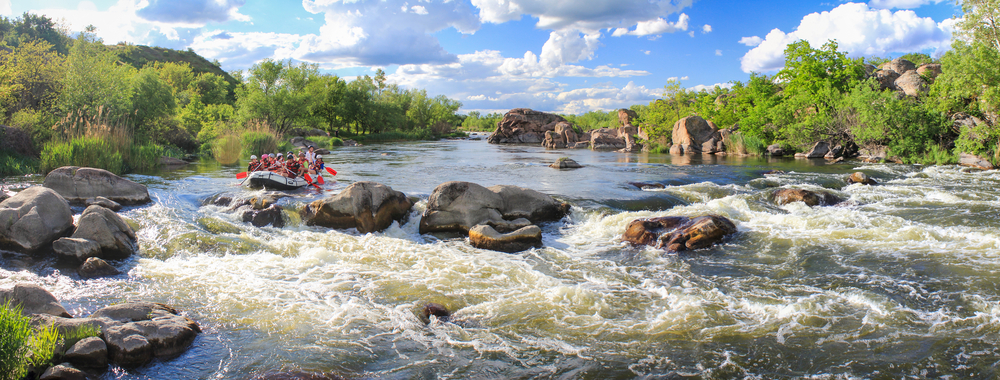Pacuare River, Costa Rica -MAY 15 2021: Rafting team , summer extreme water sport. Group of people in a rafting boat, beautiful adrenaline ride down the river. Panoramic view