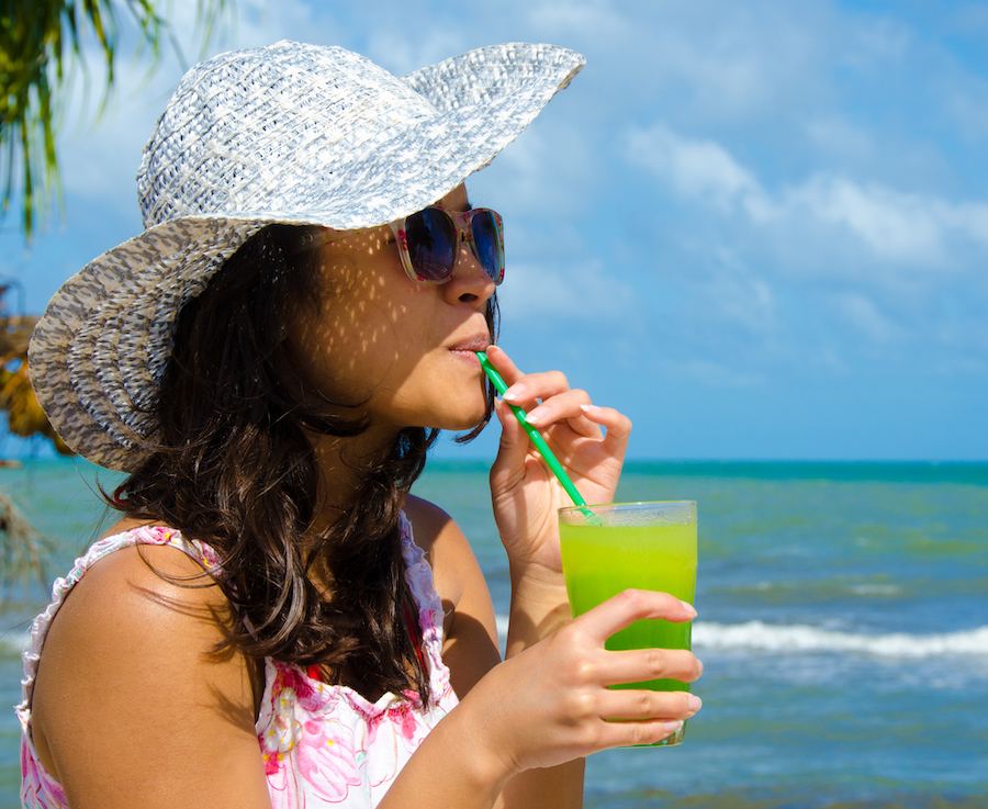 A women sipping a cocktail at the beach in Belize