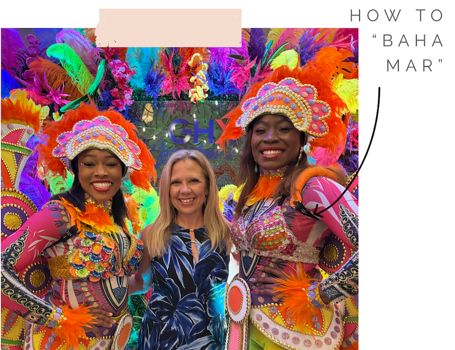 Jana smiling with two dancers dressed in colorful outfits in Baha Mar.